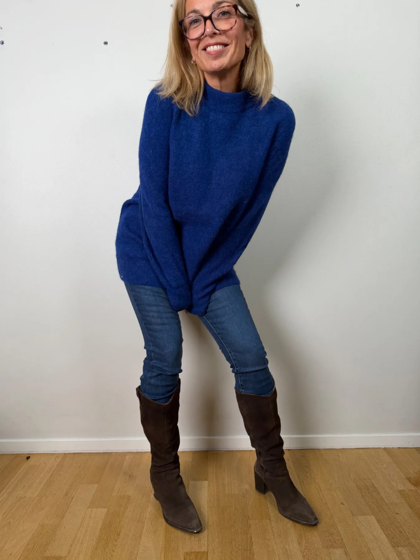 Blå stickad tröja från Arket på Manuela, med jeans och stövlar
