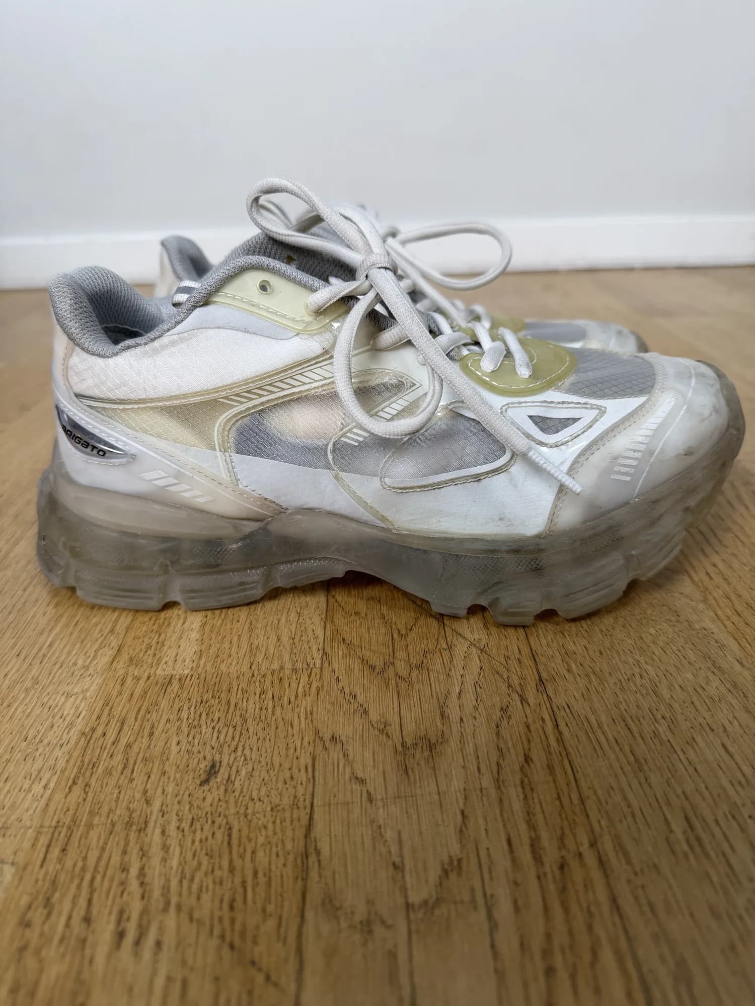 Vita sneakers med genomskinlig sula från Axel Arigato, från sidan