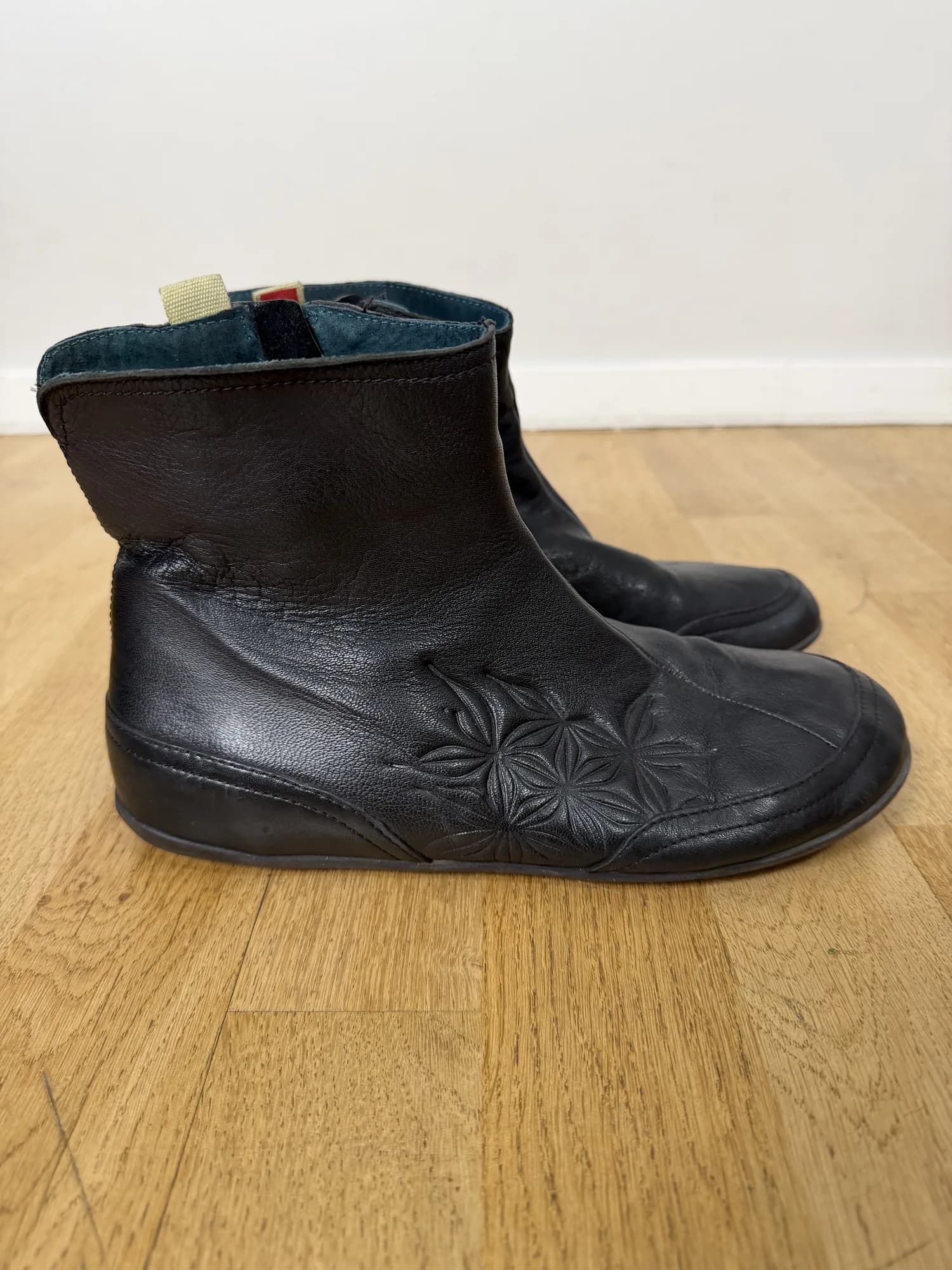 Svarta ankelboots med präglat blommönster, från sidan