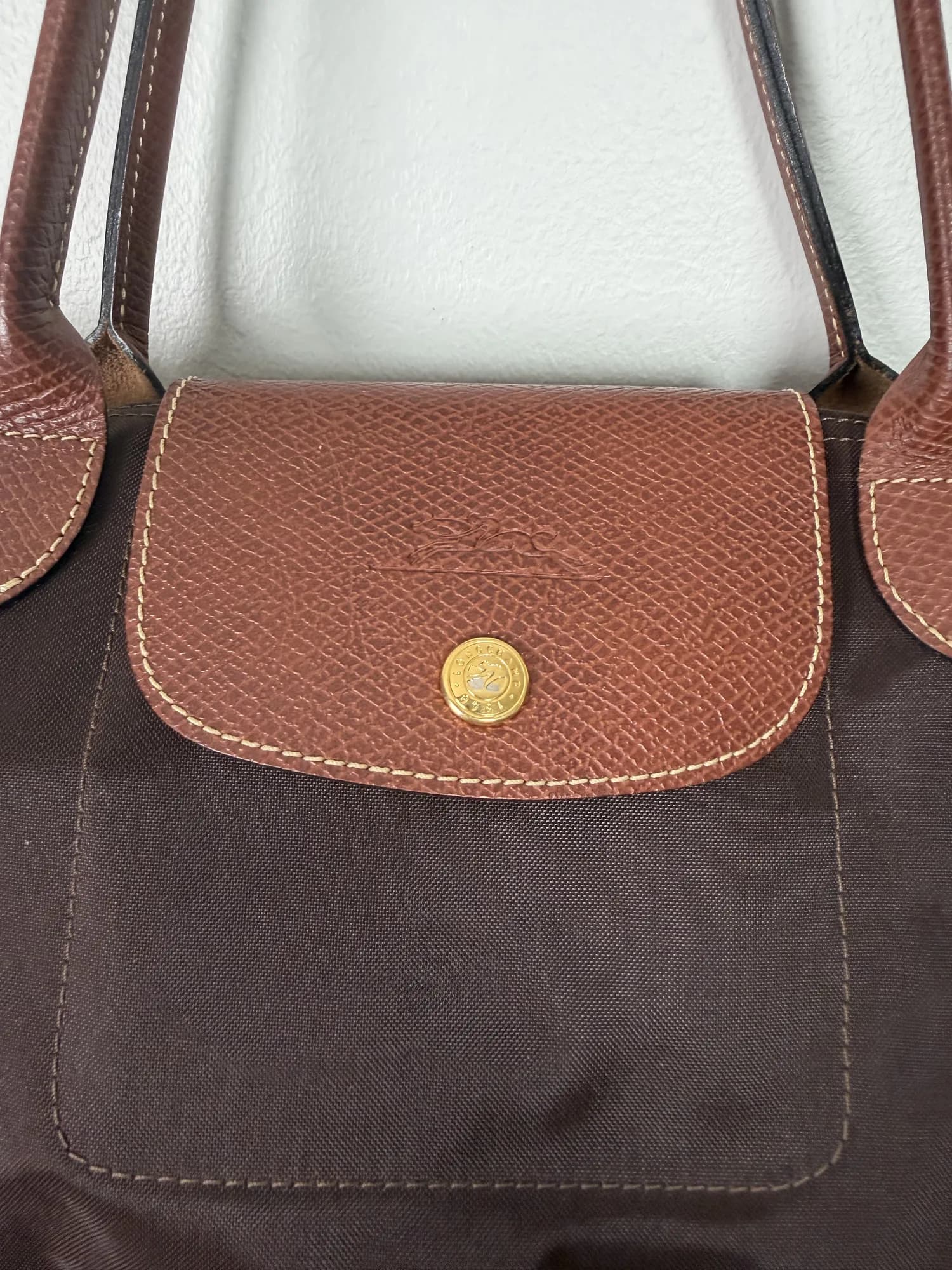 Närbild på locket i skinn och tryckknappen