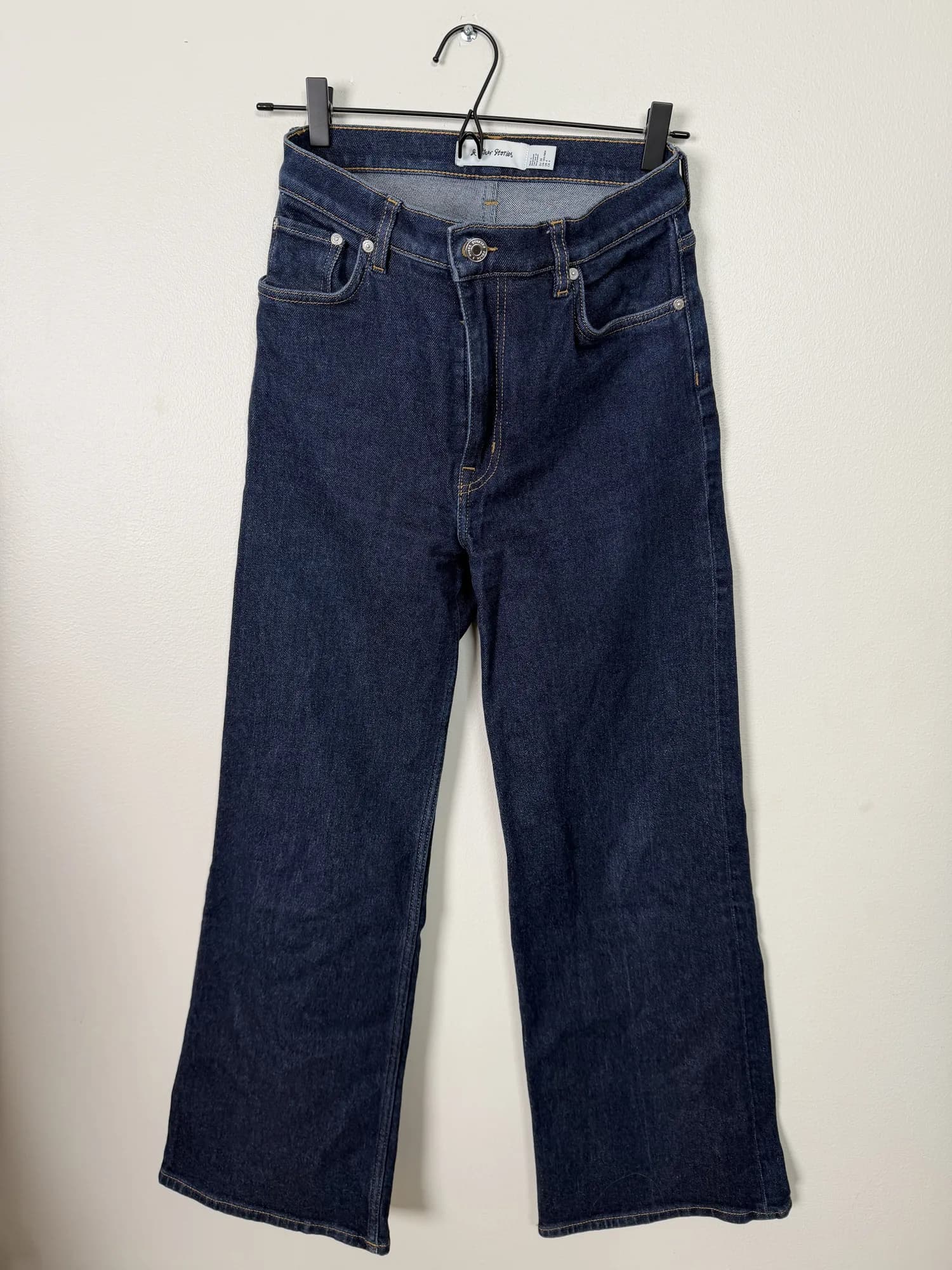 Mörkblå vida jeans från & Other Stories på galge, framifrån