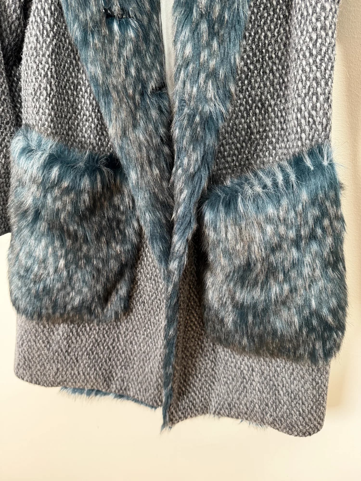 Närbild på fickorna i fuskpäls